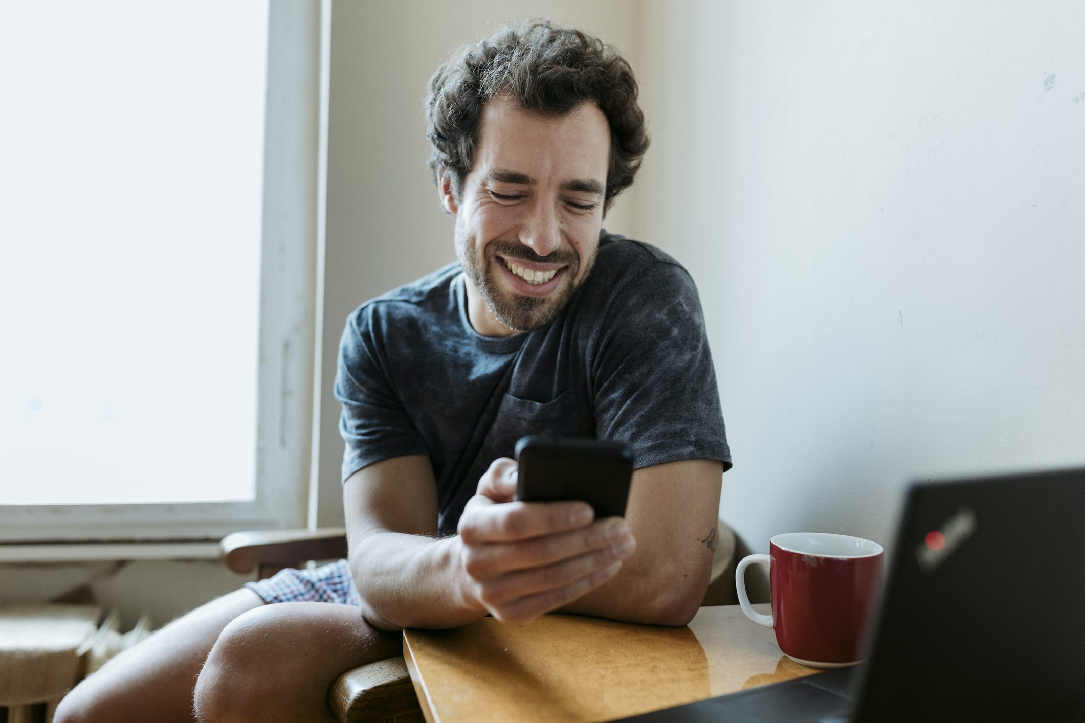 Man smiling while looking at phone