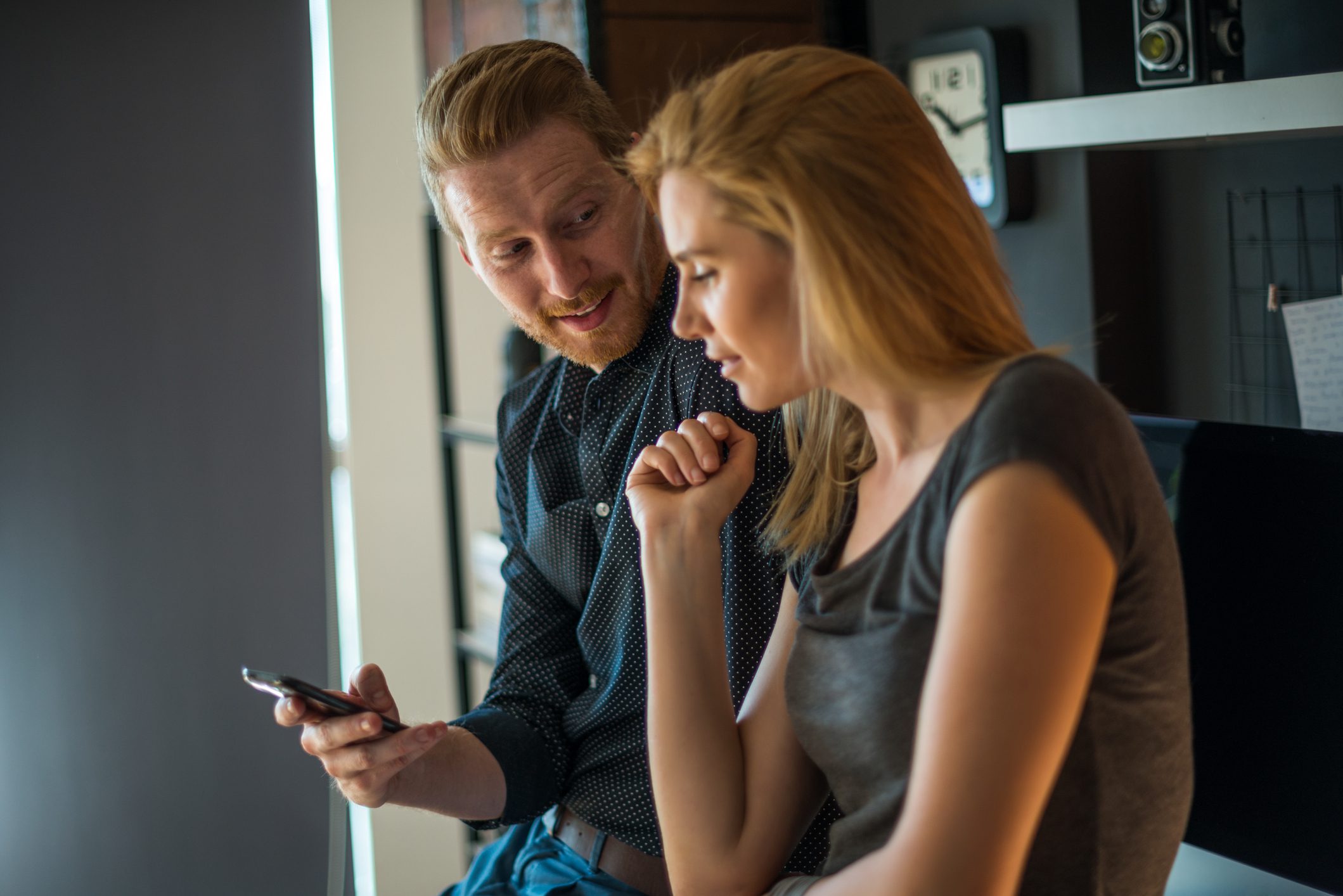 Two colleagues looking at a mobile phone